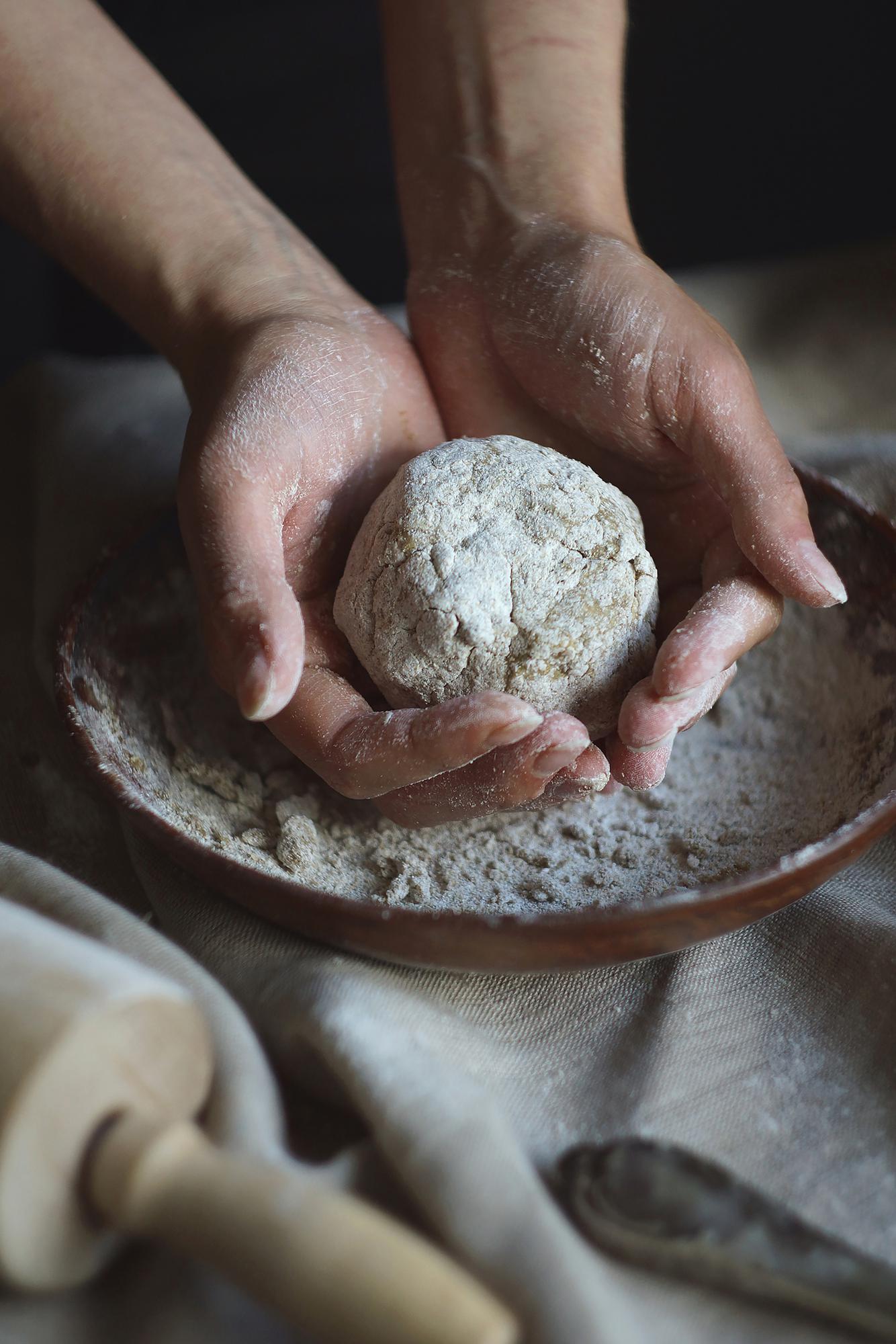 Hands kneading dough on table